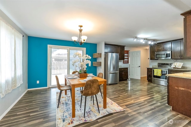 dining space with dark hardwood / wood-style floors and a chandelier