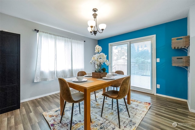 dining room with dark hardwood / wood-style floors and a notable chandelier