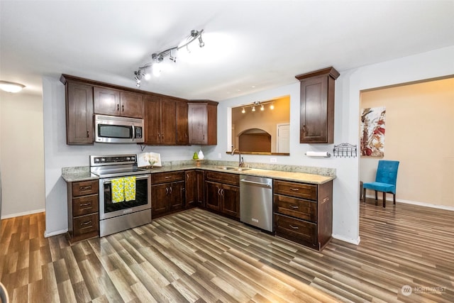 kitchen with dark brown cabinetry, sink, dark wood-type flooring, and appliances with stainless steel finishes