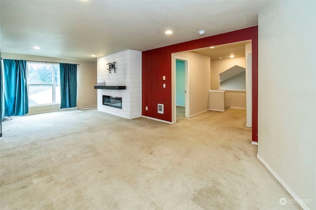 unfurnished living room featuring a large fireplace and light carpet