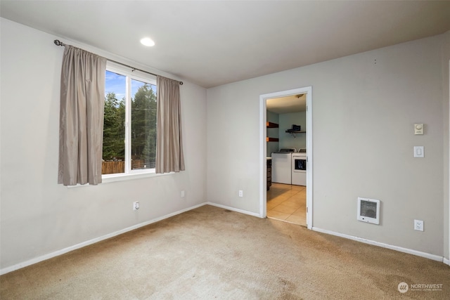 unfurnished room featuring independent washer and dryer and light colored carpet