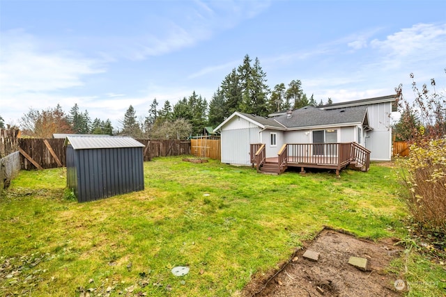 rear view of property featuring a lawn, a deck, and a storage shed