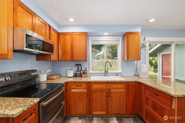 kitchen with black range with electric cooktop, sink, light stone countertops, and dark hardwood / wood-style floors