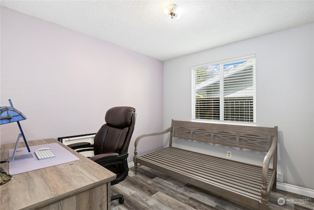 home office with dark wood-type flooring and a textured ceiling