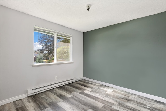 unfurnished room with light hardwood / wood-style flooring, a textured ceiling, and a baseboard radiator