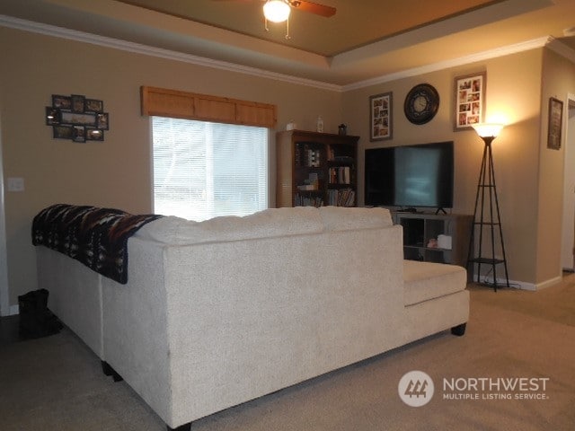 living room with ornamental molding, carpet, and ceiling fan