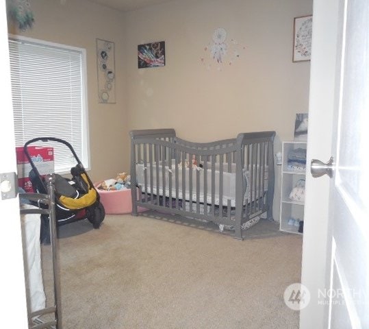 bedroom featuring carpet flooring and a crib