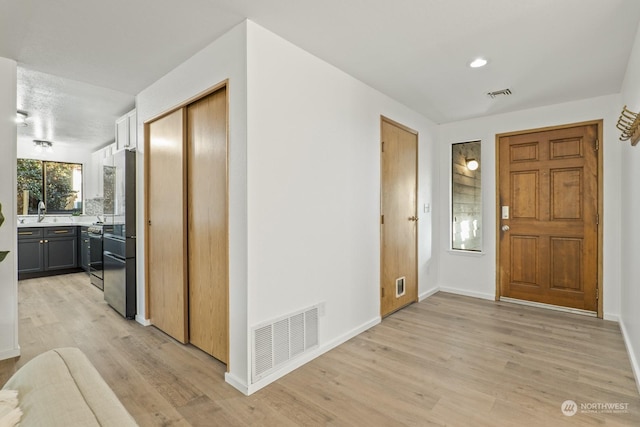 foyer entrance featuring sink and light hardwood / wood-style flooring