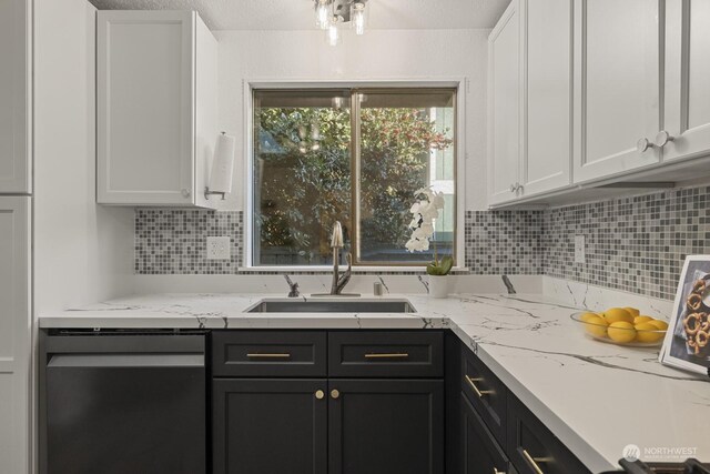 kitchen featuring sink, dishwasher, light stone countertops, decorative backsplash, and white cabinets