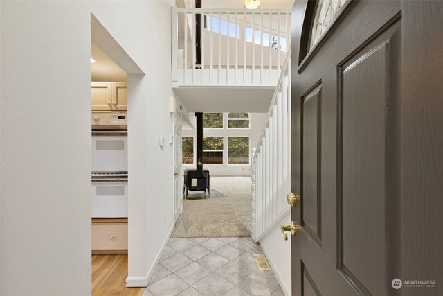 carpeted entryway with a healthy amount of sunlight and a wood stove