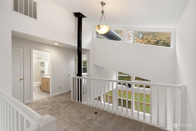 corridor with lofted ceiling and light carpet