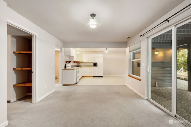 unfurnished living room with light colored carpet