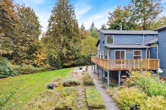 rear view of property featuring a deck and a lawn