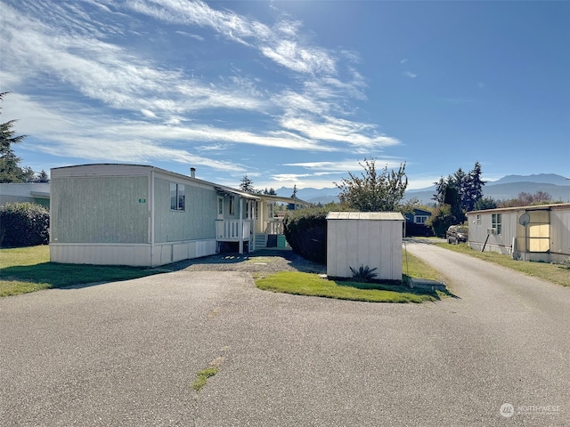 view of side of property featuring a storage unit and a mountain view