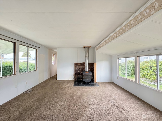 unfurnished living room with a wood stove and carpet floors