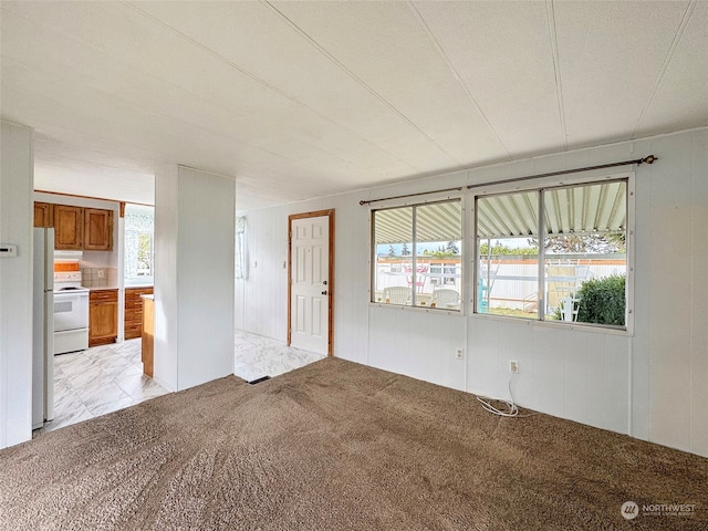 carpeted empty room with a wealth of natural light, a textured ceiling, and a water view