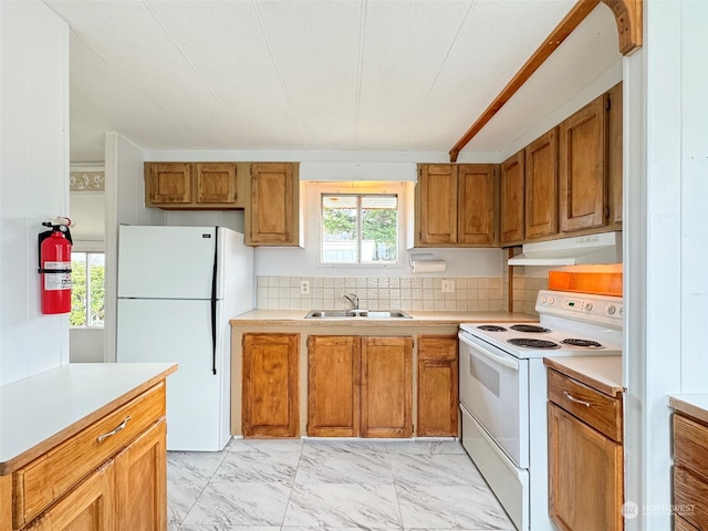 kitchen featuring sink, white appliances, and tasteful backsplash