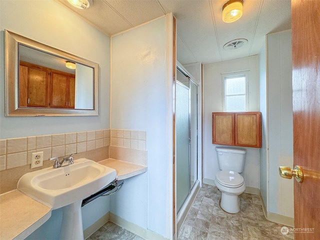 bathroom with backsplash, a shower with shower door, a textured ceiling, and toilet