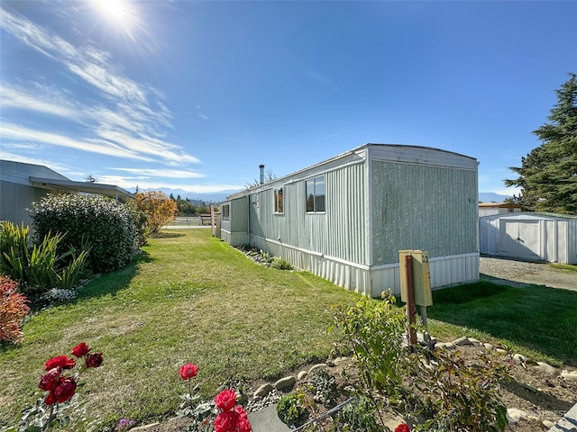 view of side of property with a storage unit and a lawn