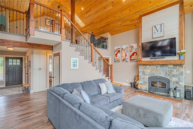 living room featuring wood ceiling, beam ceiling, wood-type flooring, a fireplace, and high vaulted ceiling