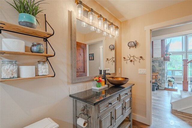 bathroom with vanity, toilet, and hardwood / wood-style floors