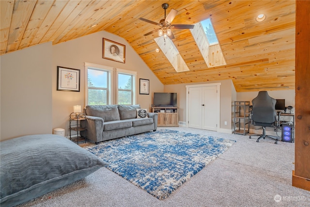 carpeted bedroom with vaulted ceiling with skylight, wood ceiling, and ceiling fan