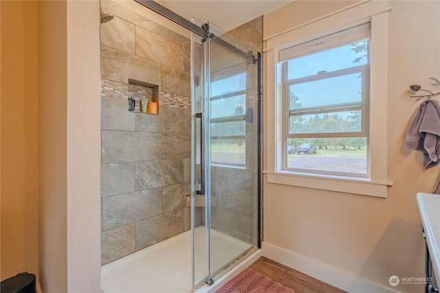 bathroom with a shower with door and hardwood / wood-style flooring