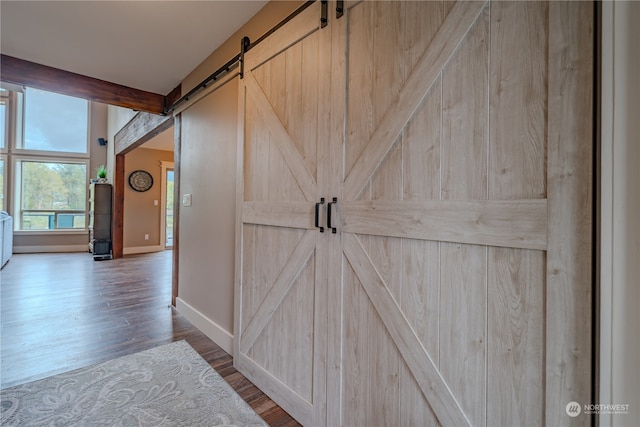 corridor with a barn door and hardwood / wood-style flooring