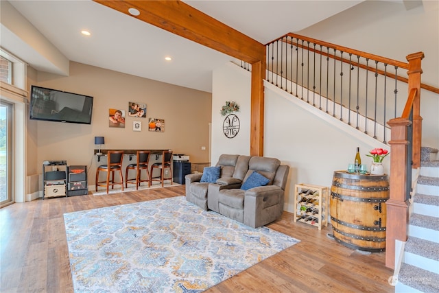 living room with beamed ceiling and light hardwood / wood-style flooring