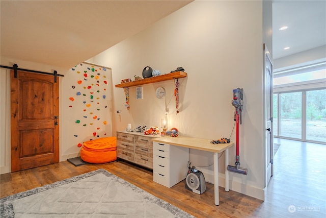 interior space with a barn door and hardwood / wood-style flooring