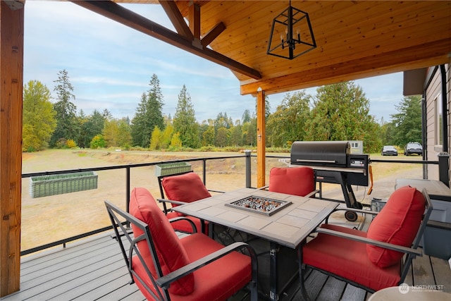 deck featuring an outdoor fire pit and a grill