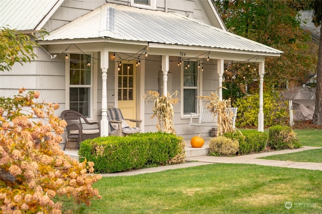 property entrance with a porch and a lawn