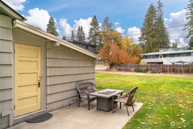 view of patio featuring an outdoor fire pit and fence