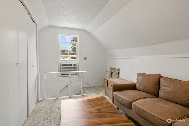 carpeted living area featuring a textured ceiling and vaulted ceiling