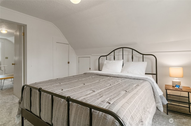 carpeted bedroom featuring a textured ceiling and vaulted ceiling