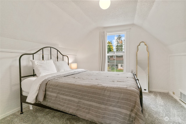 bedroom featuring a textured ceiling, vaulted ceiling, carpet flooring, and baseboards