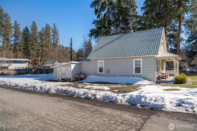 exterior space with metal roof and fence