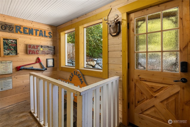 interior space featuring plenty of natural light, hardwood / wood-style flooring, and wooden walls