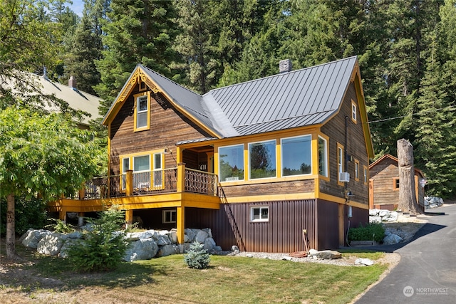 view of front facade with a wooden deck and a front yard