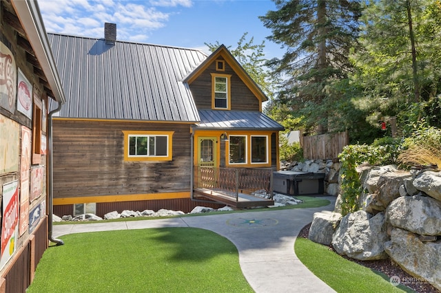 view of front of home with a hot tub and a front yard