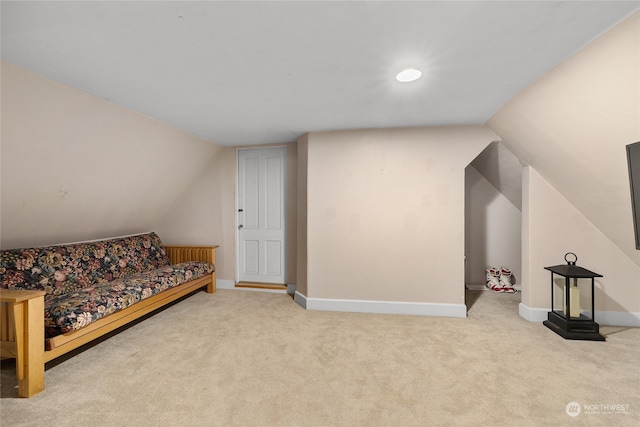 sitting room with vaulted ceiling and light colored carpet