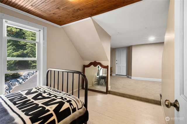 bedroom with light hardwood / wood-style floors, wood ceiling, crown molding, and vaulted ceiling