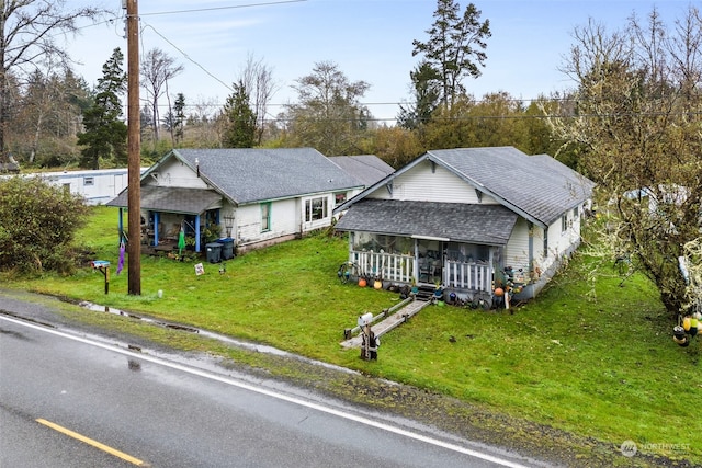 view of front of home with a sunroom and a front lawn