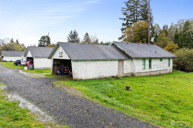 view of side of home featuring an outdoor structure and a yard