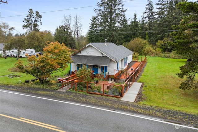 view of front of home with a wooden deck and a front lawn