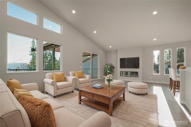 living room with baseboards, light wood-style floors, a towering ceiling, and recessed lighting