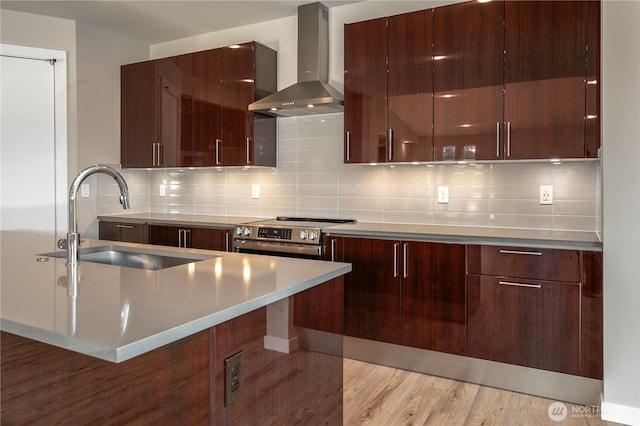 kitchen featuring a sink, wall chimney exhaust hood, and modern cabinets