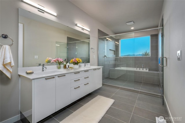 full bath featuring double vanity, a stall shower, tile patterned flooring, and a sink