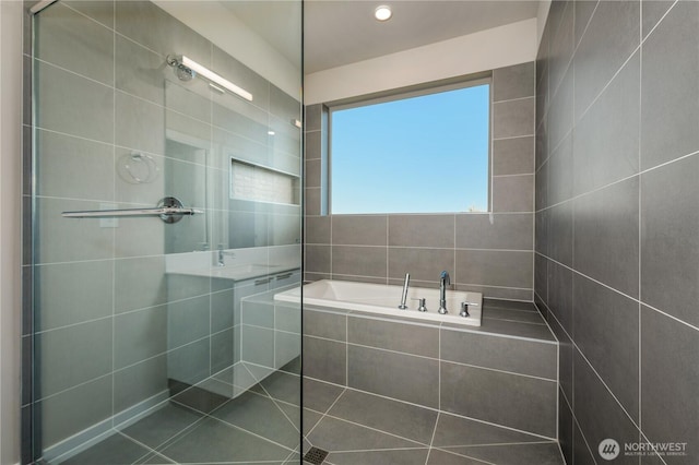 bathroom with a garden tub and a tile shower