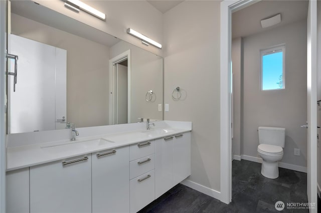 full bath with baseboards, a sink, and toilet